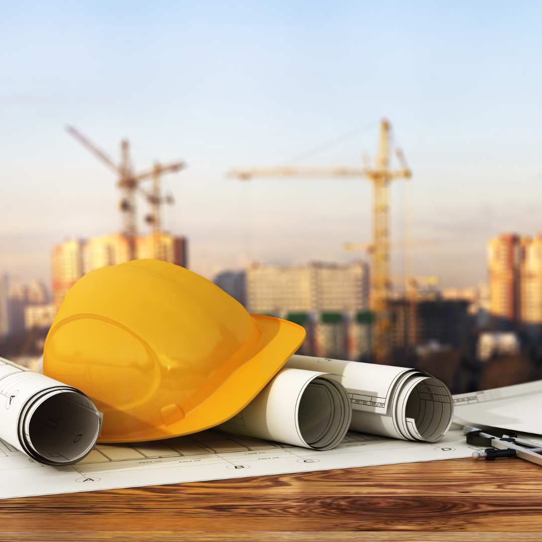 Construction site in the background with plans and a hard hat